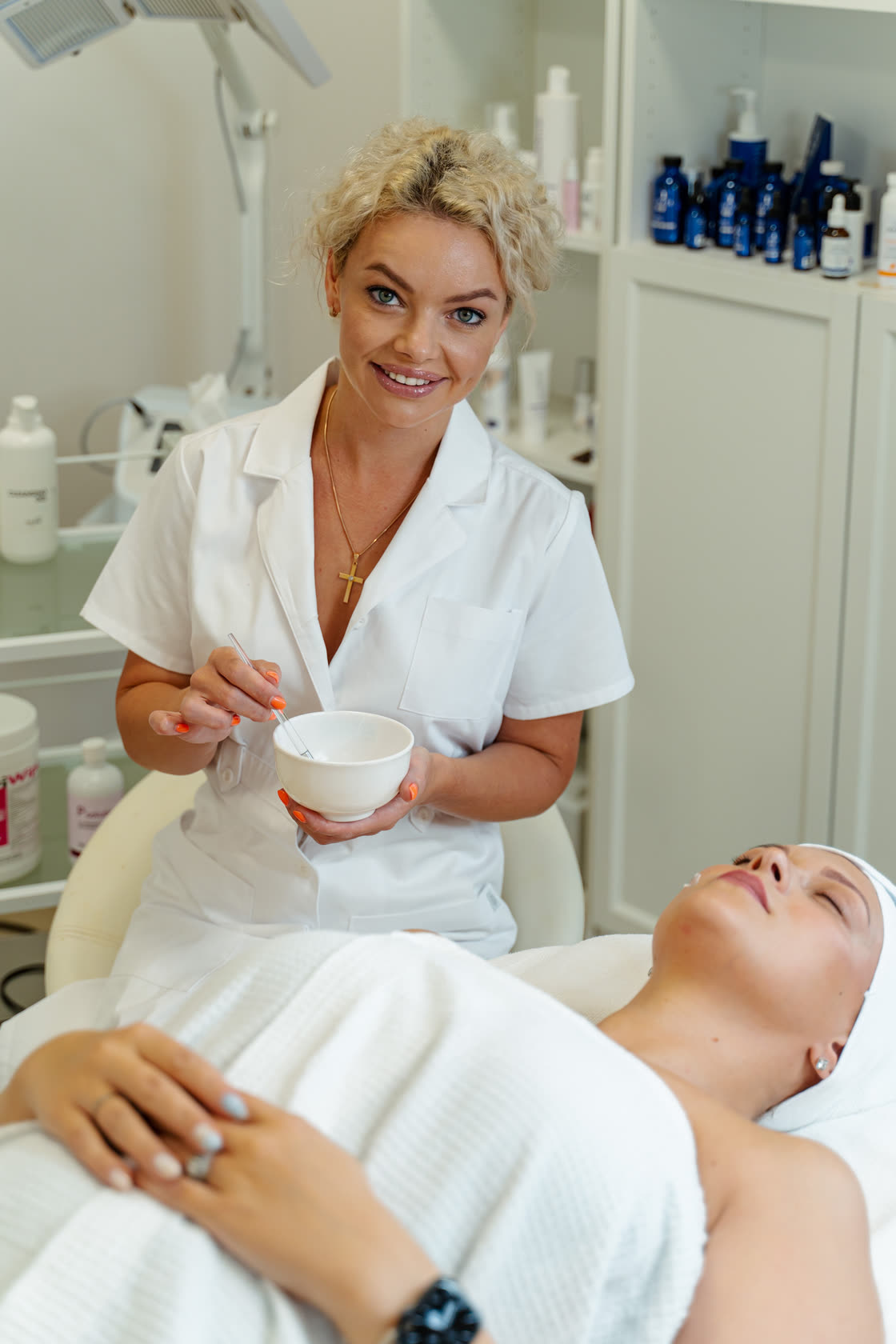Aesthetician at Metro Skin Care preparing a treatment mask for a client in the Troy, Michigan treatment room